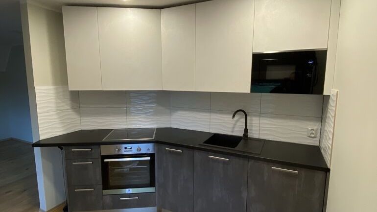 Nyoppusset, moderne kjøkken med hvite skapdører og grå hvitevarer